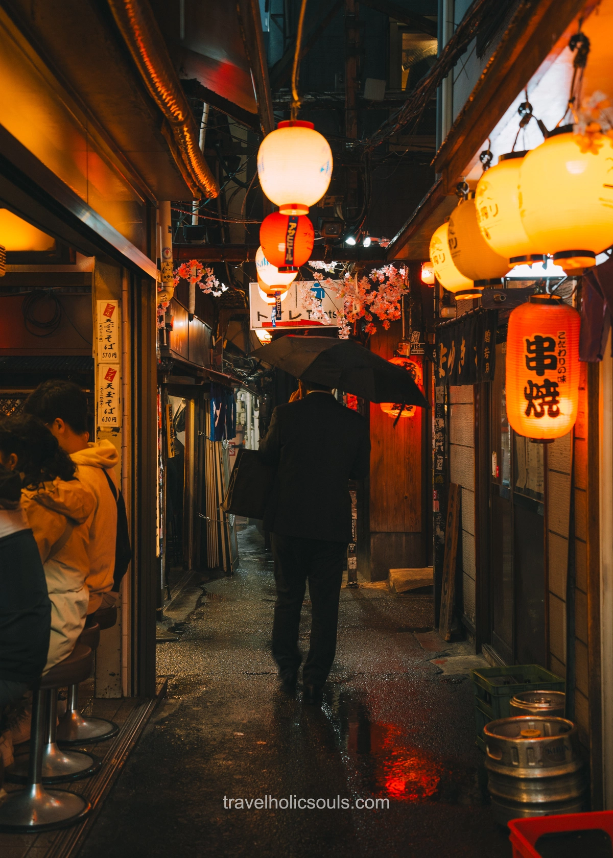 uomo che cammina di sera lungo le Omoide Yokocho a Tokyo